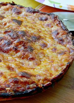 a pizza sitting on top of a wooden table