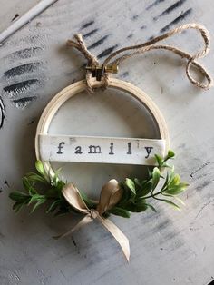 a wooden sign hanging on the side of a wall next to a wreath with greenery