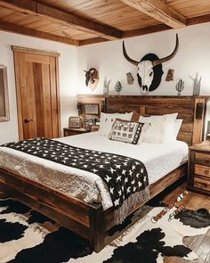 a bed room with a neatly made bed and cow head on the wall