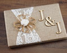 the wedding guest book is decorated with burlock and lace, which reads j & j