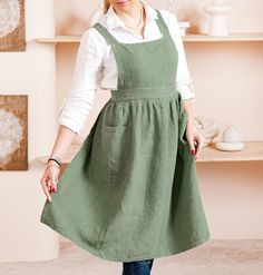 a woman standing in front of shelves wearing an apron