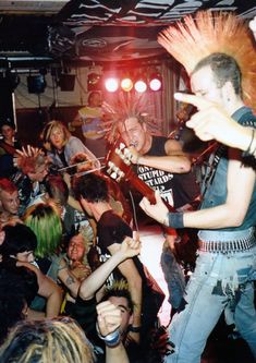 a group of people that are standing in front of a microphone and some guitar players