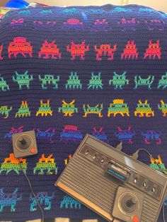 an old fashioned boombox sitting on top of a couch next to a crocheted blanket