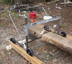 a machine that is sitting on top of a piece of wood in the woods next to a fire hydrant