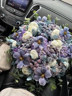 a bouquet of flowers sitting on the dashboard of a car