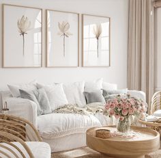 a white living room with wicker furniture and flowers on the coffee table in front of it