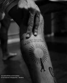 a black and white photo of a person with a tattoo on his leg