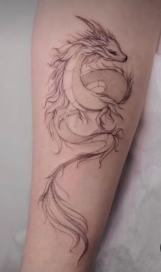 a woman's arm with a dragon tattoo on it