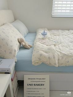 a bed sitting next to a book shelf with a stuffed animal on top of it