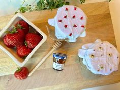 some strawberries are sitting on a wooden table