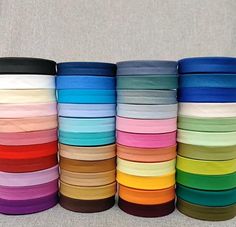 many colors of satin ribbon are stacked on top of each other