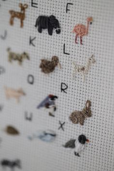 a cross stitch pattern with letters and animals on it