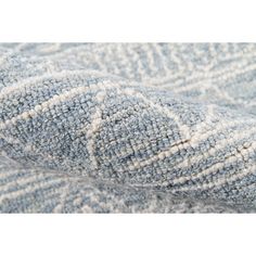 close up view of the blue and white textured fabric on top of a bed