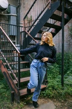 a woman standing on the stairs in front of a building