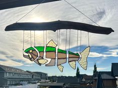 a stained glass fish mobile hanging from a window