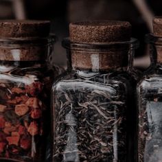 three glass jars filled with different types of spices