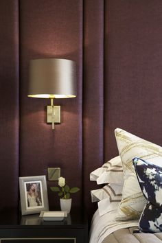 a bed room with a neatly made bed next to a night stand and a lamp