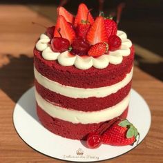 a red velvet cake with white frosting and strawberries on top