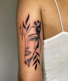 a woman's face with leaves and cross tattoo on her arm, done in black ink