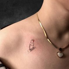 a small bird tattoo on the chest