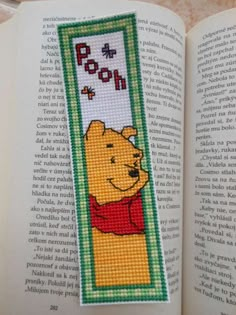 a cross stitch bookmark with winnie the pooh on it's front page