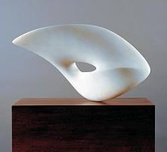 a white sculpture sitting on top of a wooden block