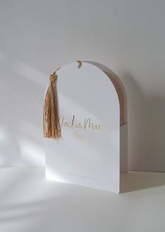 a white card with a tassel hanging from it