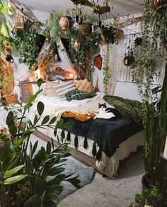 a bed with plants hanging from it's sides in a room filled with potted plants