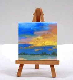 an easel with a blue painting on it