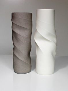 two white and grey vases sitting side by side