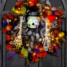 a wreath decorated with halloween decorations and skeleton hands is displayed in front of a door