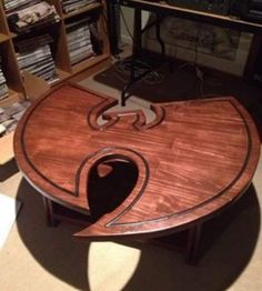 a wooden table sitting in the middle of a room filled with books and dvds on shelves