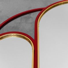 two red and gold mirrors sitting next to each other on a gray tablecloth covered floor