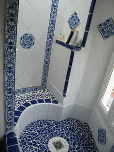 a bathroom with blue and white tiles on the walls