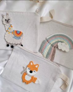 three bags with embroidered animals on them and one has a rainbow in the back ground