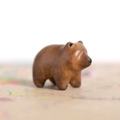 a brown bear figurine sitting on top of a table