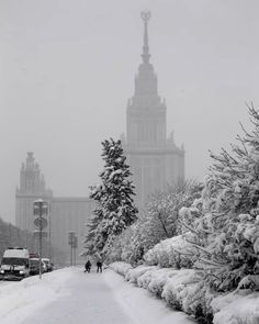 people walking down a snowy street in front of a tall building