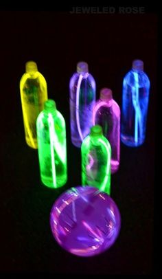 glowing bowling balls with the words night bowling written in neon colors on them, against a black background