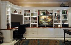 a home office with built in bookshelves and desk