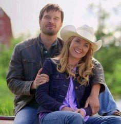 a man sitting next to a woman on top of a bench