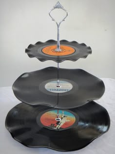 three black records stacked on top of each other with an orange disc in the middle