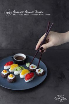 a plate with sushi and chopsticks being held by someone's hand