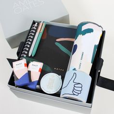 an open box containing notebooks, pens, and other personal care items in it