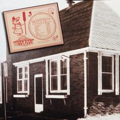 an old black and white photo of a small brick building with a sign above it