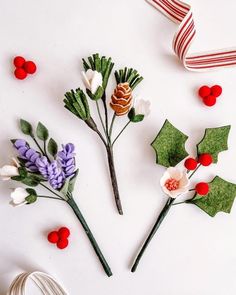 paper flowers are laid out on a white surface with red and green decorations around them