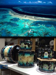 the drums are on display in front of an image of blue water and white sand