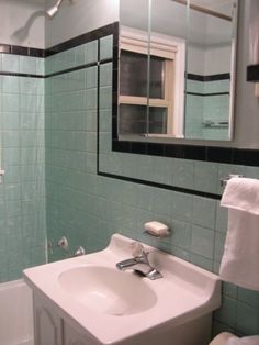 a white sink sitting under a bathroom mirror next to a bath tub and shower stall