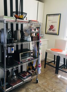 a kitchen with black and white stripes on the wall, shelves filled with pots and pans