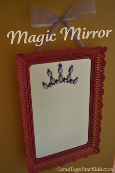 a mirror hanging on the wall with a bow around it's edge that says magic mirror