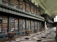 an old library filled with lots of books and tables next to each other on checkered flooring